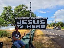 Patrick Cline Aka Lahaina Jesus Sitting Beside the Highway with his cross